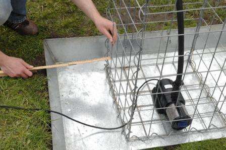 Аккуратно обкладываем насос камнями, чтобы придать установке необходимую жесткость