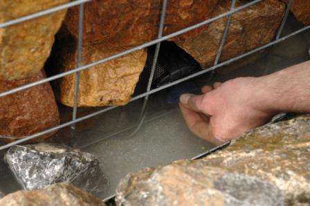 Аккуратно обкладываем пластиковую трубку каменьями так, чтобы она все время находилась в центре конструкции